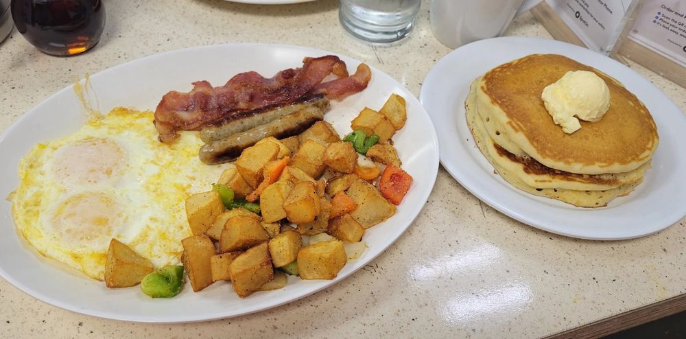 American breakfast with eggs, bacon, sausage, home potatoes and buttermilk pancakes