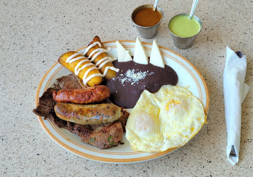 Desayuno Chapín: fried plantains with crema, black beans with queso fresco, eggs, longaniza, chorizo and steak