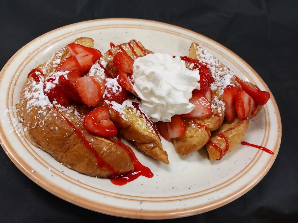 French toast topped with fresh strawberries, powdered sugar and whipped cream